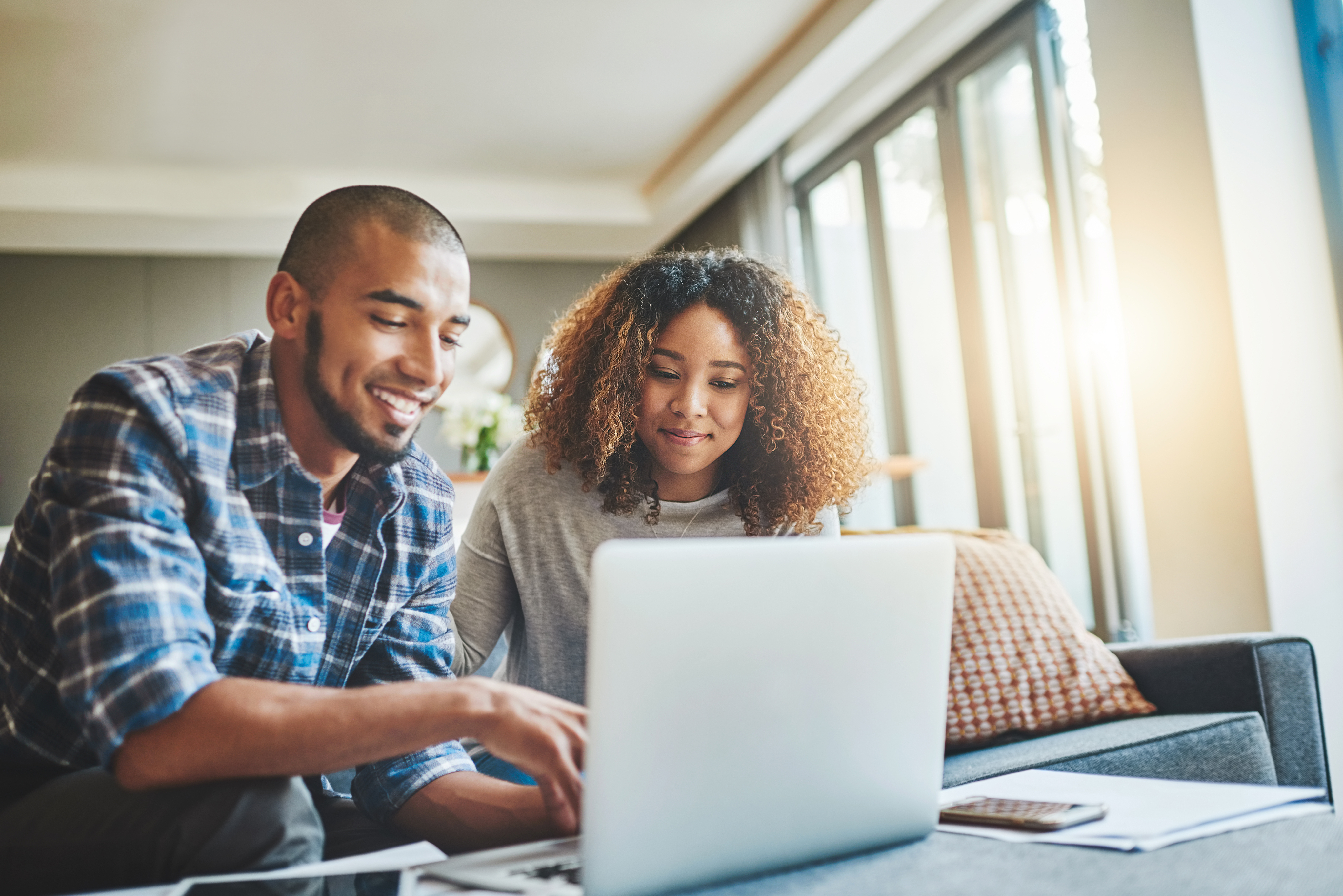 A couple looking at a laptop together at home